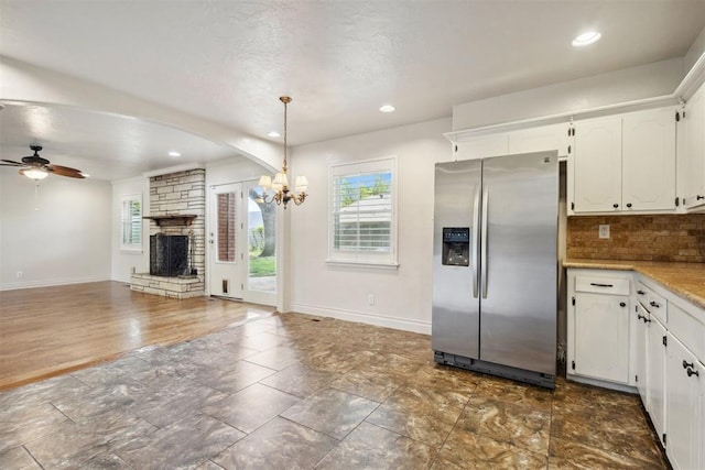 kitchen featuring white cabinetry, a wealth of natural light, stainless steel fridge with ice dispenser, and a fireplace
