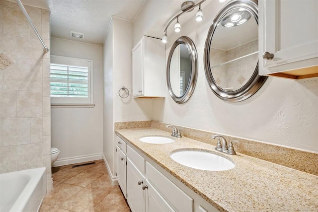 bathroom featuring visible vents, a sink, tile patterned flooring, and toilet