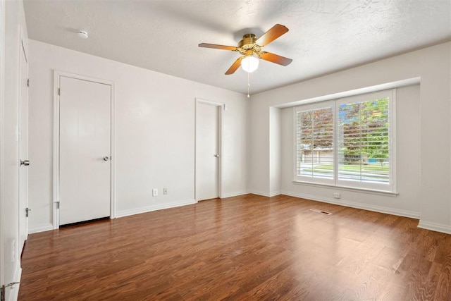 unfurnished bedroom with baseboards, a ceiling fan, wood finished floors, and visible vents