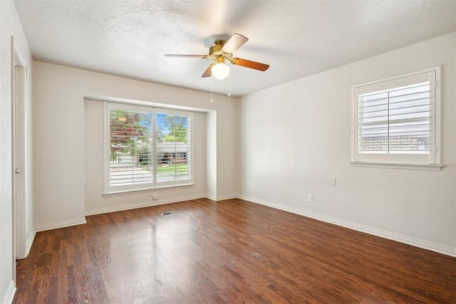 spare room with a ceiling fan, baseboards, visible vents, and wood finished floors