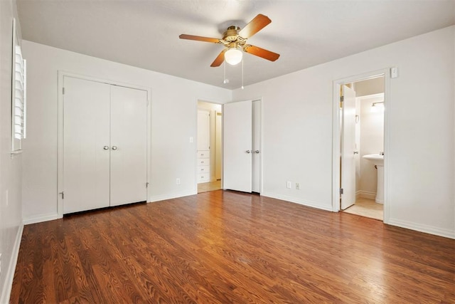 unfurnished bedroom featuring baseboards, connected bathroom, ceiling fan, and wood finished floors