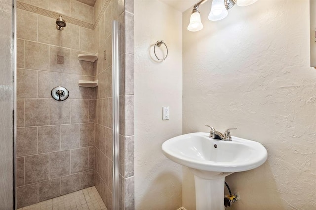 full bath with a textured wall and a shower stall
