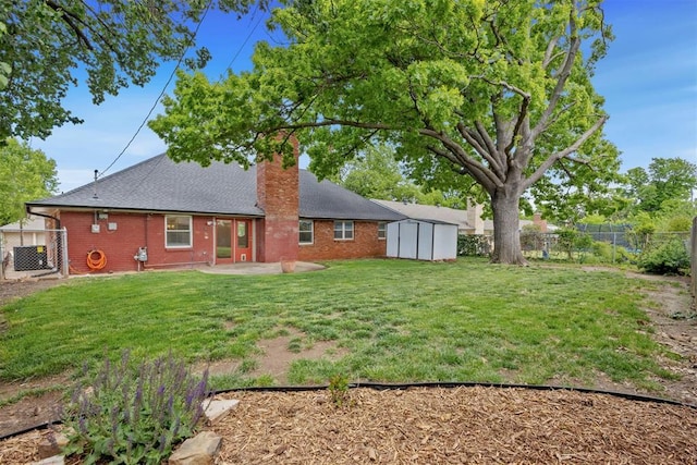 back of house with a patio, a fenced backyard, a shed, a chimney, and brick siding