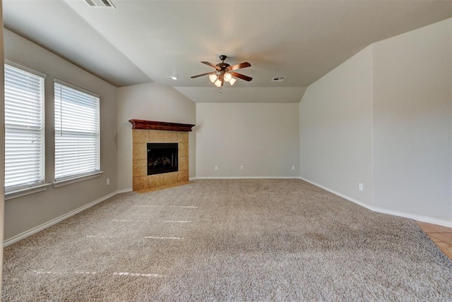 unfurnished living room featuring ceiling fan, carpet, a fireplace, lofted ceiling, and baseboards