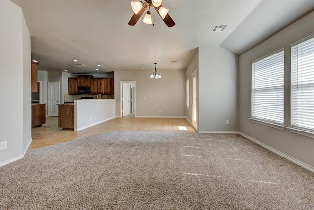 unfurnished living room featuring plenty of natural light, a chandelier, a ceiling fan, and recessed lighting