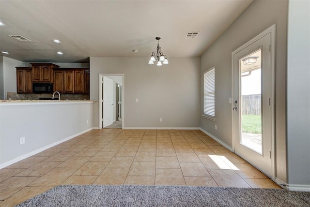 kitchen with black microwave, a chandelier, decorative light fixtures, recessed lighting, and a sink