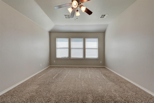 empty room featuring light colored carpet, a ceiling fan, baseboards, and vaulted ceiling