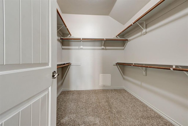 spacious closet featuring carpet floors and vaulted ceiling