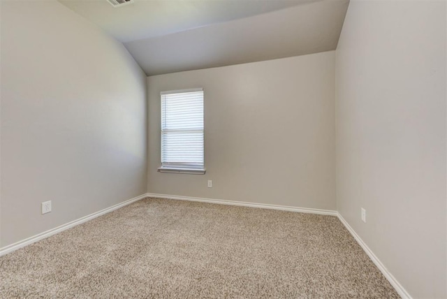 unfurnished room with carpet floors, vaulted ceiling, and baseboards