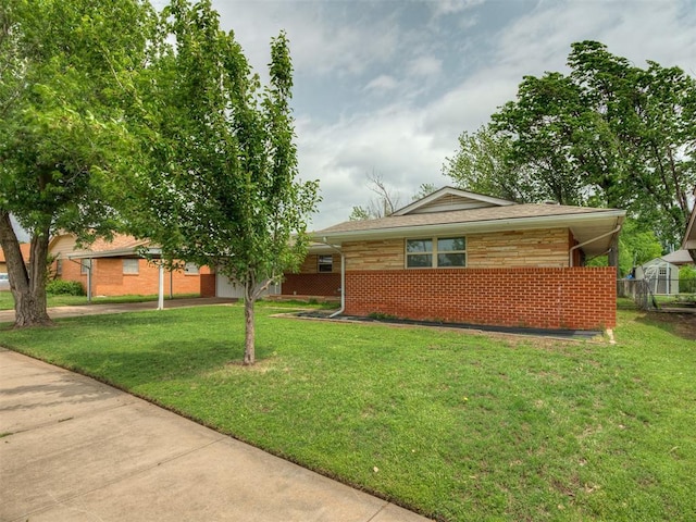view of front of property with fence, brick siding, and a front yard