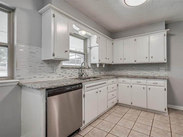 kitchen featuring stainless steel dishwasher, white cabinetry, and a sink
