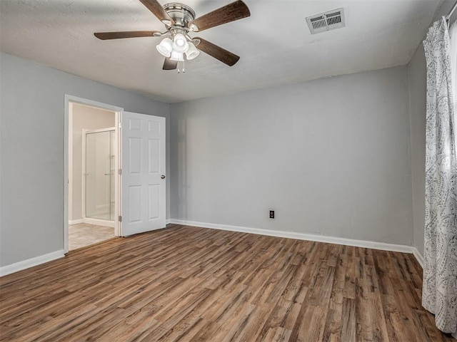 unfurnished room with baseboards, visible vents, and wood finished floors