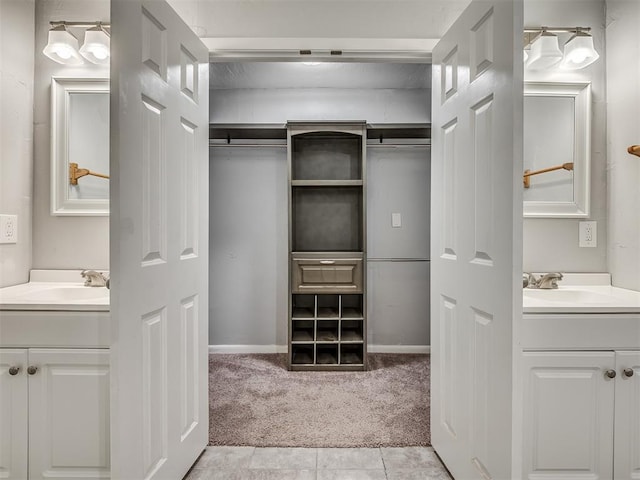 spacious closet with light tile patterned flooring, light carpet, and a sink