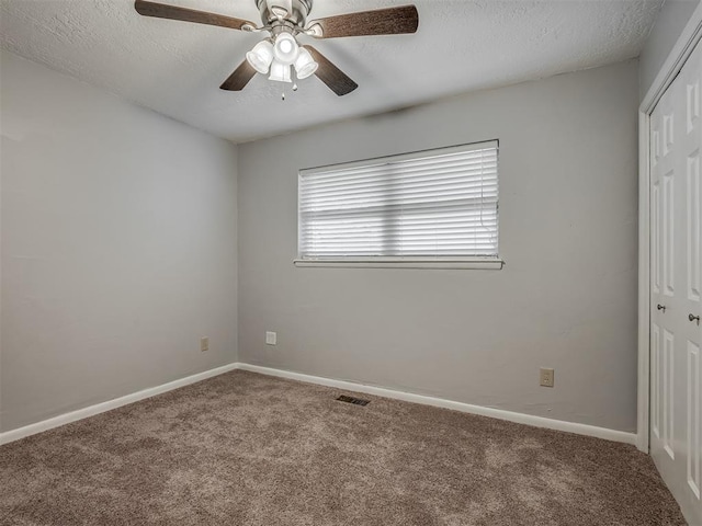 unfurnished bedroom with carpet flooring, a textured ceiling, baseboards, and a closet