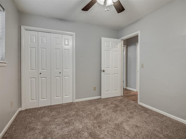 unfurnished bedroom with a closet, baseboards, ceiling fan, and carpet flooring