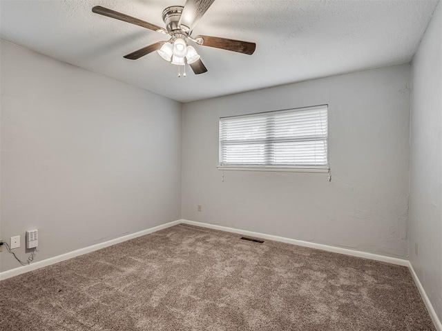 carpeted spare room featuring visible vents, a ceiling fan, baseboards, and a textured ceiling