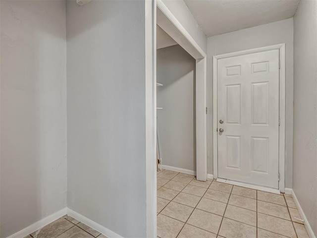 interior space with baseboards and light tile patterned floors