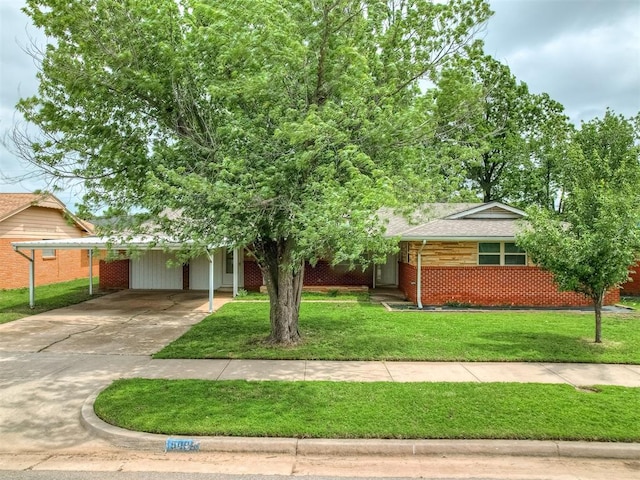 view of front of property with a front yard, brick siding, concrete driveway, a shingled roof, and an attached carport