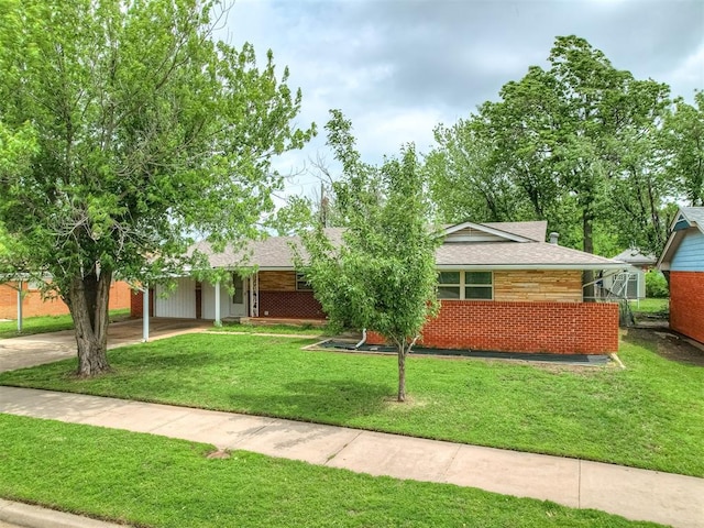 ranch-style house featuring a shingled roof and a front lawn
