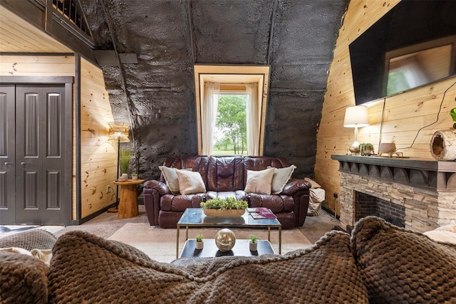 living area featuring wooden walls and a fireplace