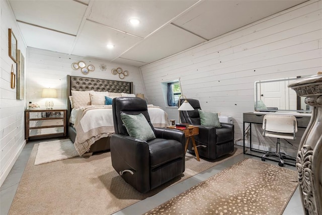 bedroom featuring wood walls and concrete flooring