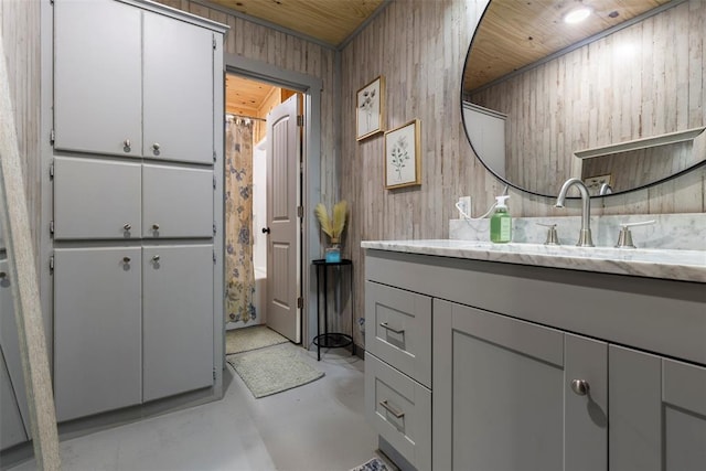 bathroom featuring vanity, wood walls, concrete floors, and wooden ceiling