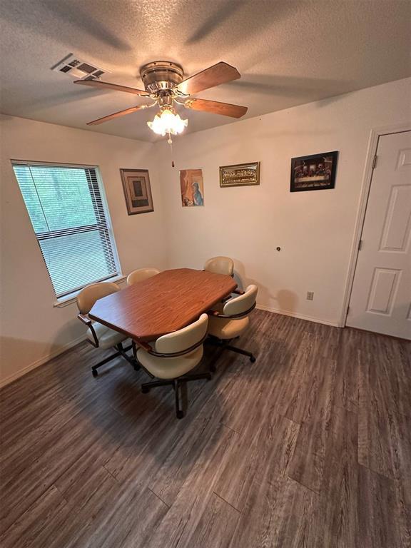 dining room with visible vents, a ceiling fan, a textured ceiling, and dark wood finished floors
