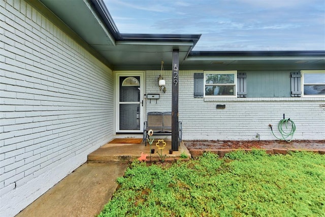 doorway to property with brick siding