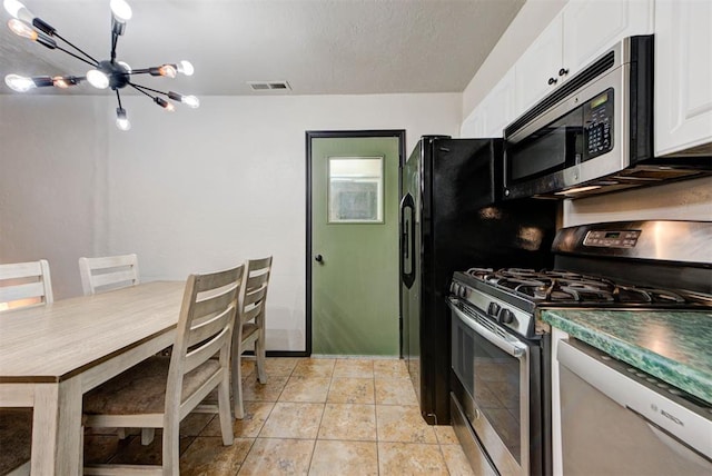 kitchen featuring visible vents, dark countertops, appliances with stainless steel finishes, a chandelier, and white cabinetry