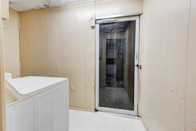 interior space with laundry area, wood walls, and washer / dryer