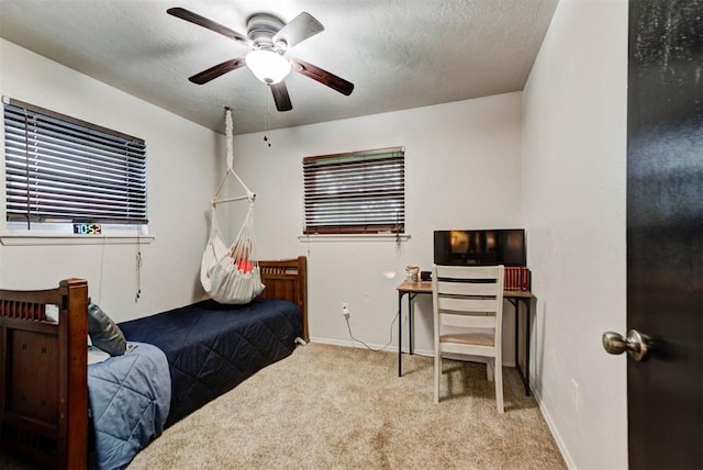 bedroom with carpet floors, a textured ceiling, baseboards, and ceiling fan