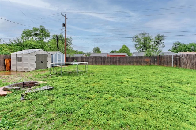 view of yard with a fenced backyard, an outdoor structure, and a shed