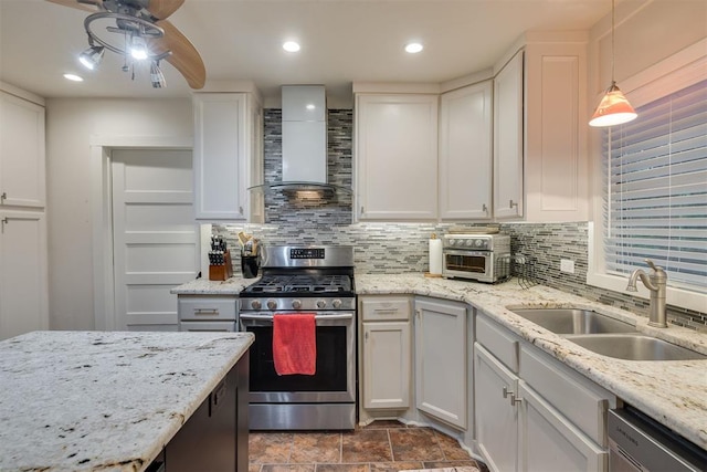 kitchen with wall chimney range hood, appliances with stainless steel finishes, backsplash, and a sink