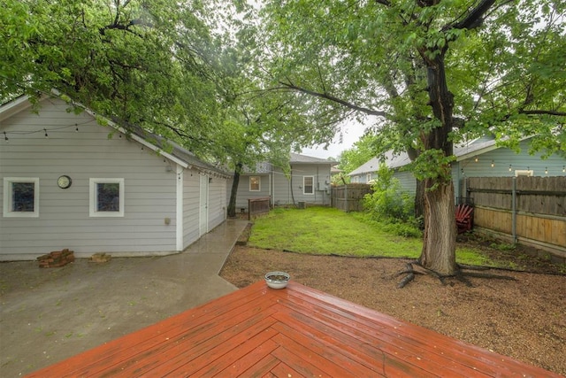 wooden terrace with a yard and a fenced backyard