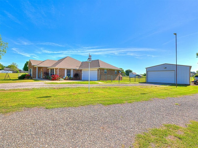 910860 S 3350th Rd, Wellston, OK 74881 - ranch-style home featuring fence, a front yard, an outbuilding, driveway, and a detached garage