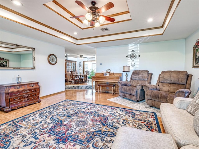 910860 S 3350th Rd, Wellston, OK 74881 - living area with wood finished floors, visible vents, ceiling fan, crown molding, and a tray ceiling