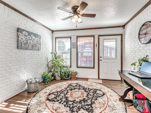910860 S 3350th Rd, Wellston, OK 74881 - entrance foyer featuring ceiling fan, brick wall, crown molding, and wood finished floors