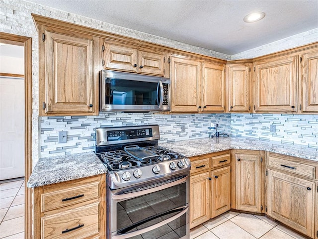 910860 S 3350th Rd, Wellston, OK 74881 - kitchen featuring a textured ceiling, stainless steel appliances, tasteful backsplash, and light tile patterned flooring
