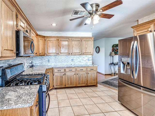 910860 S 3350th Rd, Wellston, OK 74881 - kitchen with visible vents, ceiling fan, backsplash, light tile patterned floors, and appliances with stainless steel finishes
