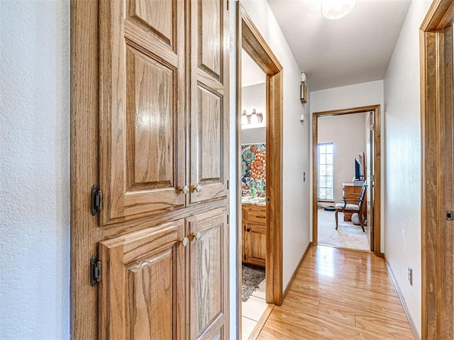 910860 S 3350th Rd, Wellston, OK 74881 - hall featuring light wood finished floors, baseboards, and a textured wall