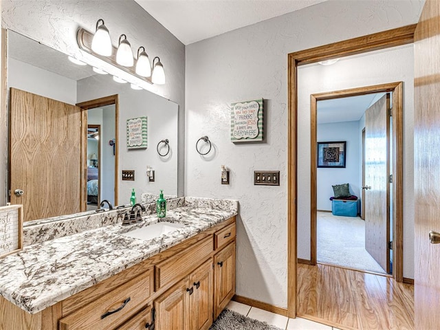 910860 S 3350th Rd, Wellston, OK 74881 - ensuite bathroom with connected bathroom, wood finished floors, baseboards, a textured wall, and vanity