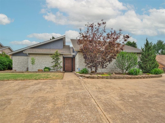 view of front facade featuring stone siding and stucco siding