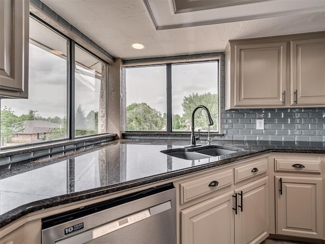 kitchen with decorative backsplash, recessed lighting, dark stone counters, a sink, and dishwasher
