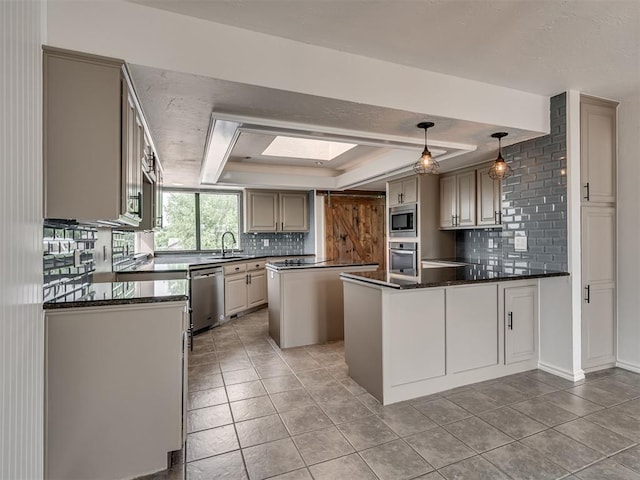 kitchen featuring appliances with stainless steel finishes, decorative backsplash, a sink, and a raised ceiling
