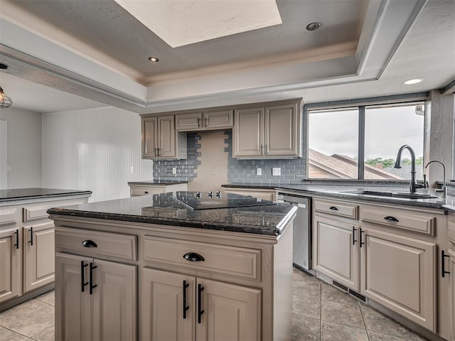 kitchen featuring a center island, a raised ceiling, tasteful backsplash, a sink, and dishwasher