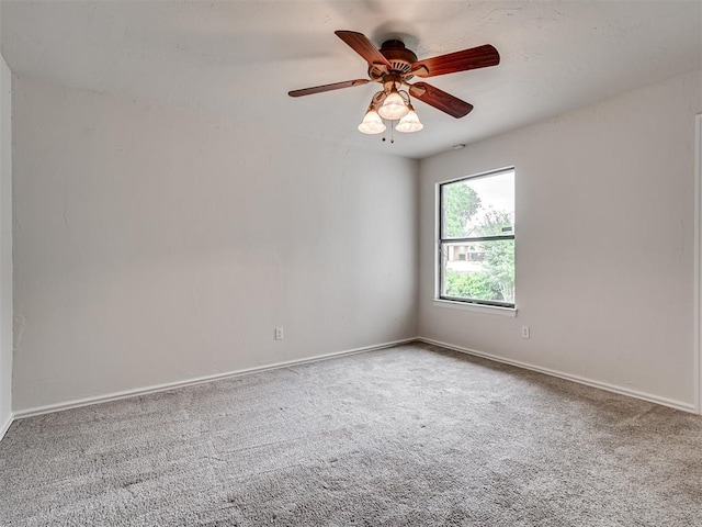 carpeted empty room with baseboards and a ceiling fan