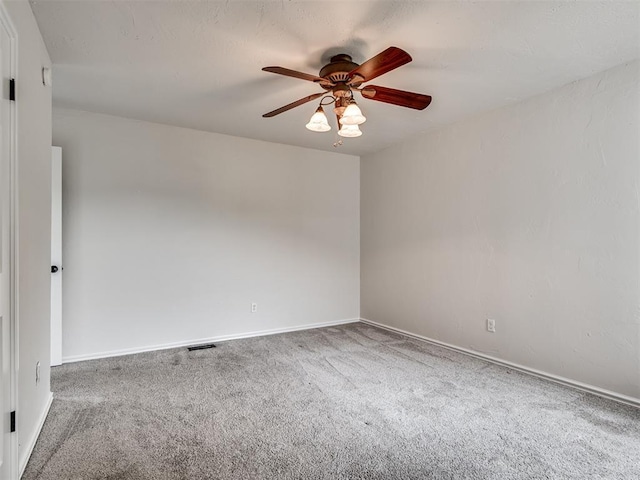 unfurnished room with carpet floors, a ceiling fan, baseboards, and visible vents