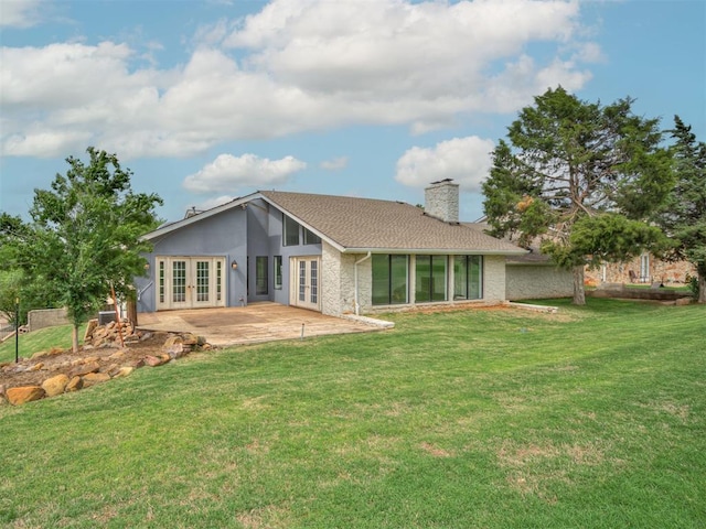 back of house featuring a patio area, a yard, french doors, and a chimney