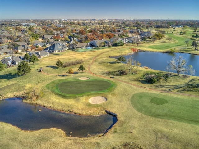 drone / aerial view featuring a residential view, view of golf course, and a water view