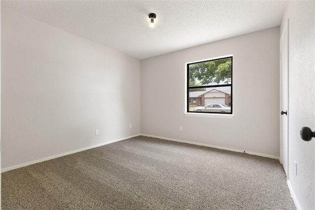 carpeted empty room featuring baseboards and a textured ceiling